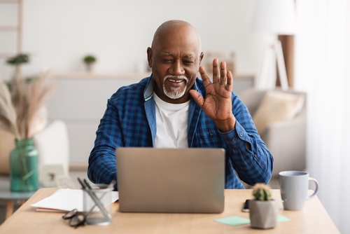 Man waving hello on laptop